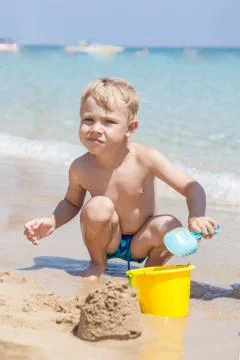 Boy playing in the sand and waves on the beach Stock Photos