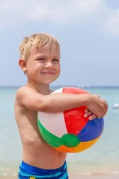 Boy playing in the sand and waves on the beach 스톡 사진