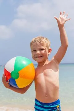 Boy playing in the sand and waves on the beach Stock Photos
