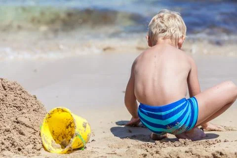 Boy playing in the sand and waves on the beach Stock Photos