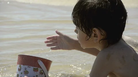 Boy playing with sand on the beach Stock Footage 50556749