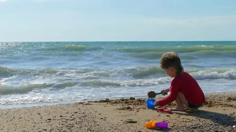 Boy playing with sand on the beach Stock Footage 78235253