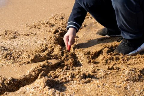 Boy playing with sand on the beach Stock Photos