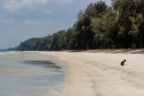 Boy playing with sand at the beach on summer,Summer holiday and vacation conc Stock Photos