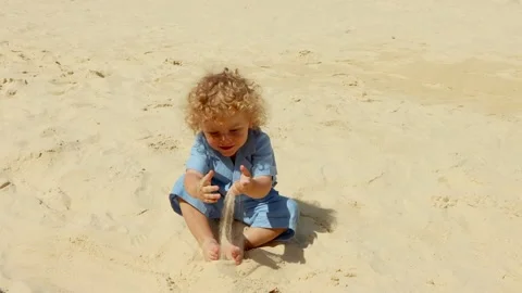 Boy playing with sand on the beach Sunny summer day, 4K Stock Footage 133907122