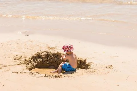 Boy playing in sand on Bournemouth beach, Dorset, UK Stock Photos