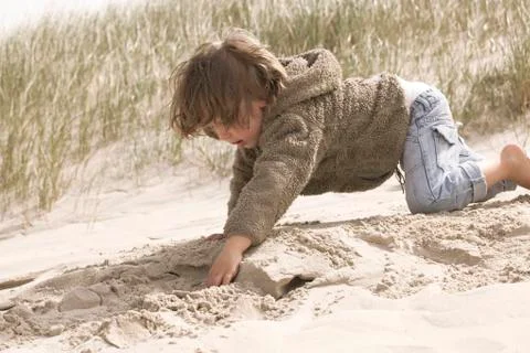 Boy playing in the sand Stock Photos