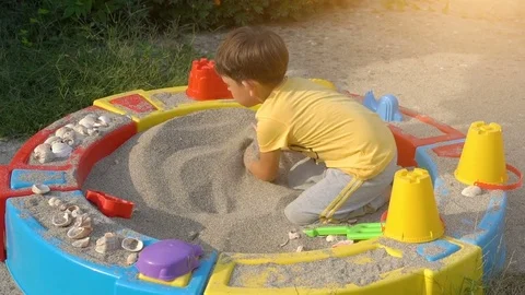Boy playing with sand in a sandbox Stock Footage 80726997