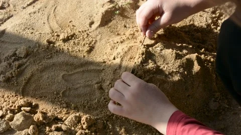 Boy playing with sand in the street 库存影片 153990743