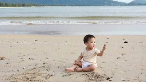 Boy playing sand on tropical beach 库存影片 35672097