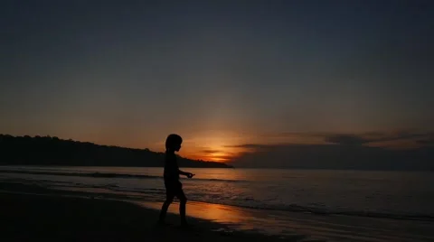 Boy playing on the sea at sunset 库存影片 50883273