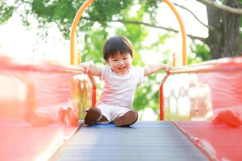 Boy playing on the slide Stock Photos