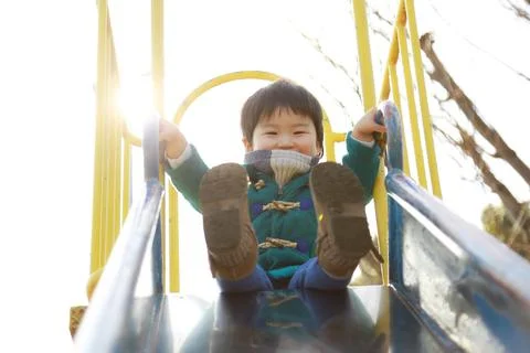Boy playing on the slide Stock Photos