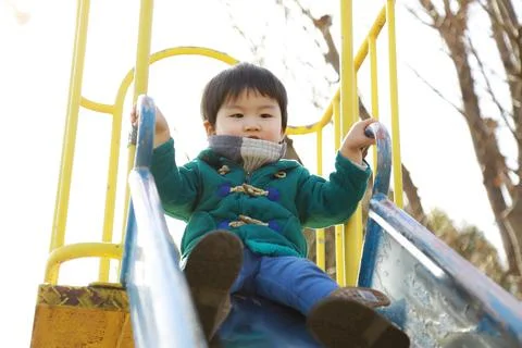 Boy playing on the slide Foto stock