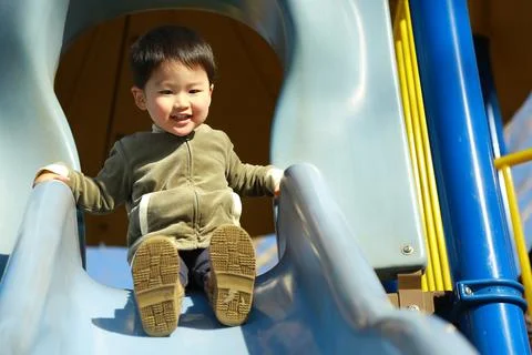 Boy playing on the slide Stock Photos
