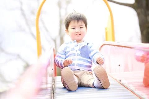 Boy playing on the slide Stock Photos
