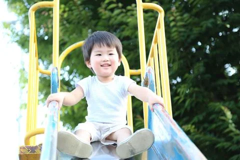 Boy playing on the slide Foto stock
