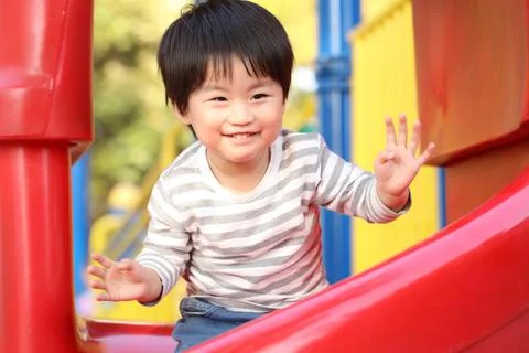 Boy playing on the slide Stock Photos