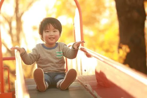 Boy playing on the slide Stock Photos