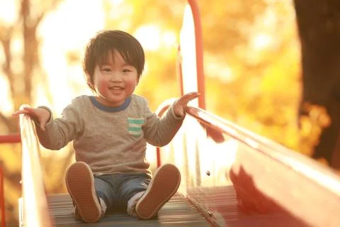 Boy playing on the slide Stock Photos