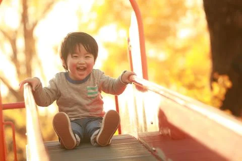 Boy playing on the slide Foto stock