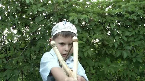 Boy playing with a slingshot Stock Footage 11234360
