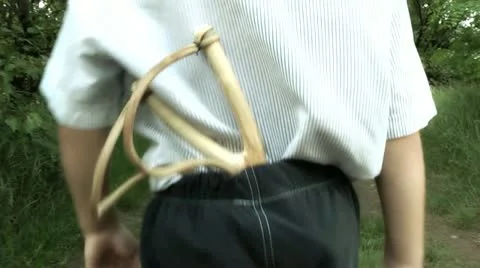 Boy playing with a slingshot 库存影片 11234533