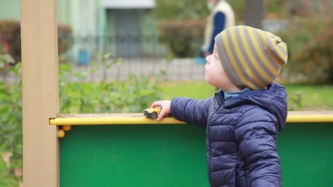 A boy is playing with a small car and explaining something Stock Footage 162777589