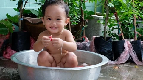 The boy is playing in a small water bath. Stock-Footage 109209090