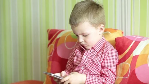 Boy is playing on the smartphone Stock Footage 74053027