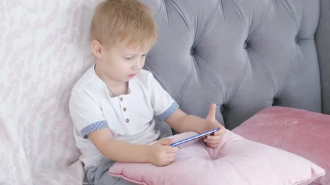 Boy playing smartphone games on sofa Stock-Footage 98969422