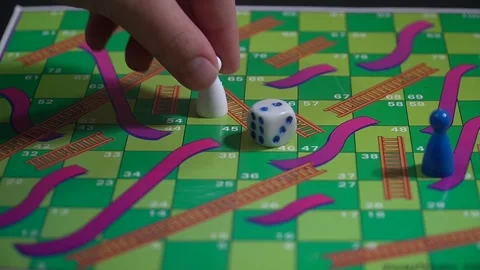 Boy playing snakes and ladders board game Stock Footage 146915575