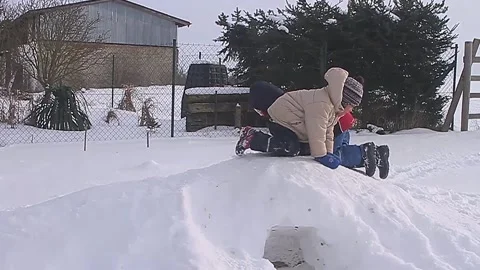 Boy playing with snow in winter making a ice Igloo with people children playing Stock Footage 321939786