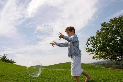 Boy playing with soap bubble Stock Photos