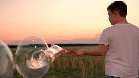 Boy playing with soap bubbles in an autumn park, slow motion. Happy childhood in Stock Footage 323969091