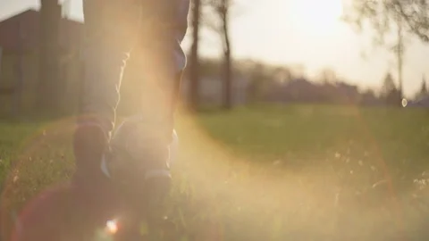 Boy playing soccer ball on the grass. Close-up of feet hitting ball in sunny Stock Footage 195086795