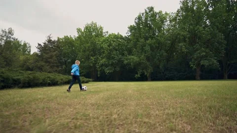Boy playing soccer in the park, keep his foot on the ball. Kid with soccer ball. Stock Footage 148168102