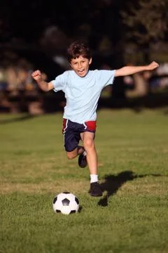 Boy playing soccer in the park Stock Photos