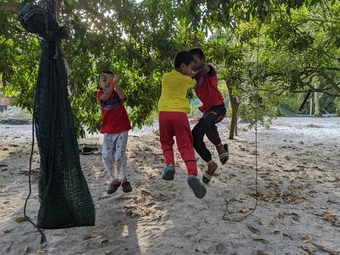 A boy is playing soccer under a tree in their yard while doing the famous soccer Stock Photos
