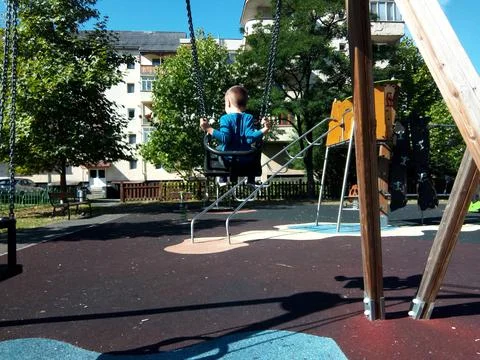 A boy is playing on the swing in the park 写真素材