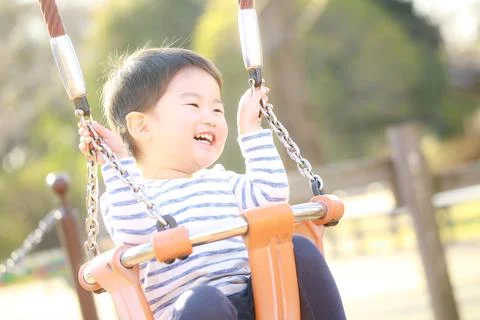 Boy playing on a swing Stock Photos