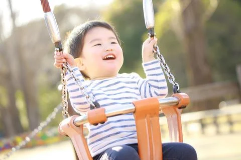 Boy playing on a swing Stock Photos