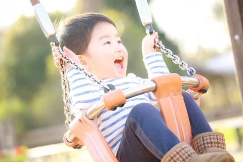 Boy playing on a swing Stock Photos