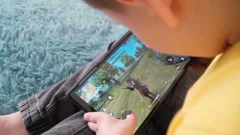 The boy is playing on the tablet. The game and emotions of the child. Stock Footage 233314750