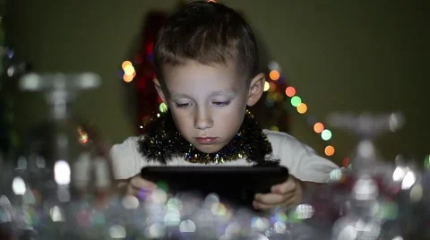 Boy playing on the tablet in the New Year's Eve Stock Footage 59790609
