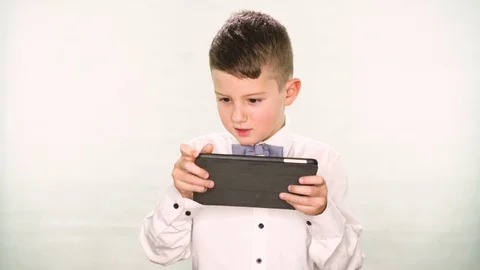 Boy playing with a tablet or smartphone on white background Stock Footage 83923219