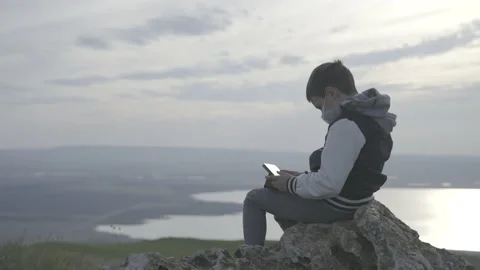 Boy playing tablet outdoors Stock Footage 141759873