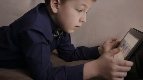 Boy playing on a tablet.Full hd video Video stock 72120175