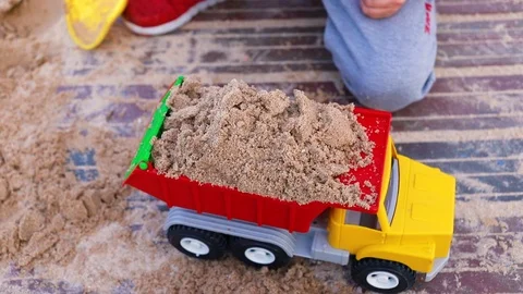Boy playing with toy car with sand on the beach Stock Footage 88995027