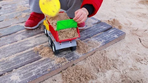 Boy playing with toy car with sand on the beach Stock Footage 88995052